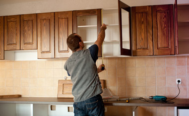 Man Using Tape Measure for Cabinet During Kitchen Remodeling Project.